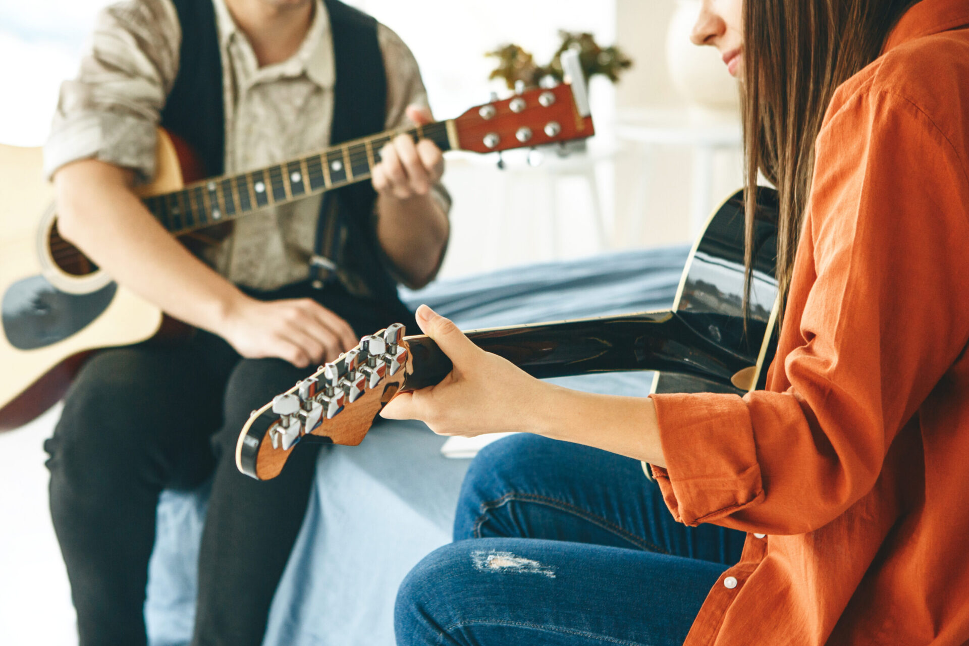 Un professeur explique à un élève les basiques pour jouer de la guitrare.